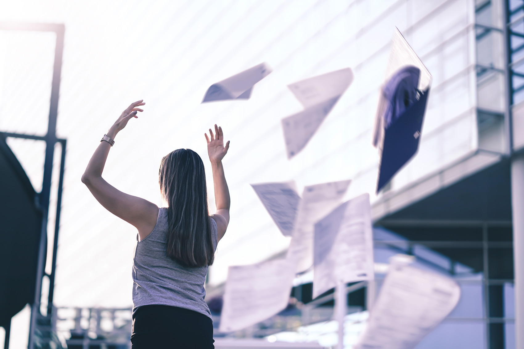 Woman Throwing Papers in Air - Quiet Quitting and The Great Resignation